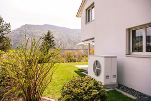 Vue latérale d’une maison individuelle équipée d’une pompe à chaleur. 